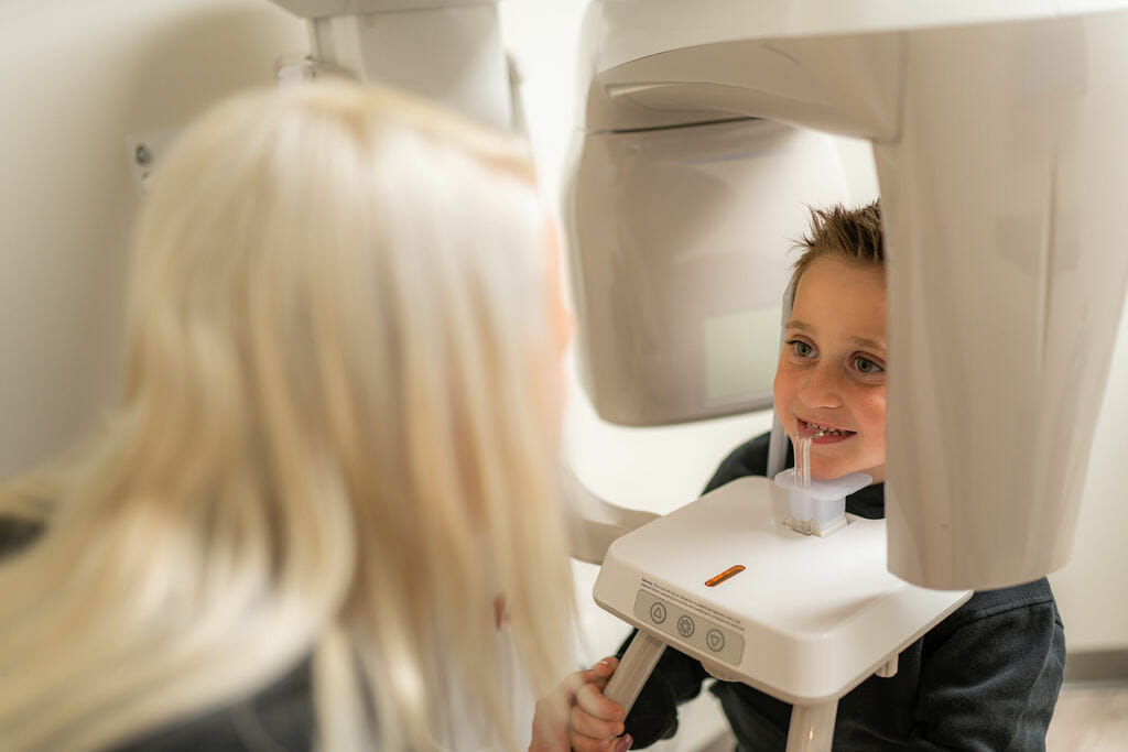 Dental hygienist preparing child for dental xray