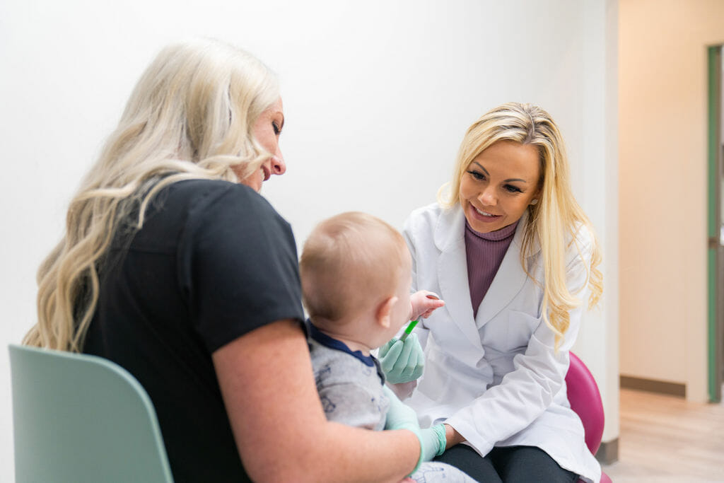 Dentist interacting with mother and baby