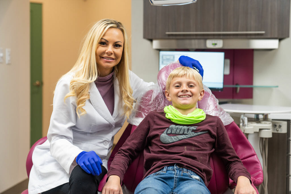Dr. Wright posing with boy in dental chair
