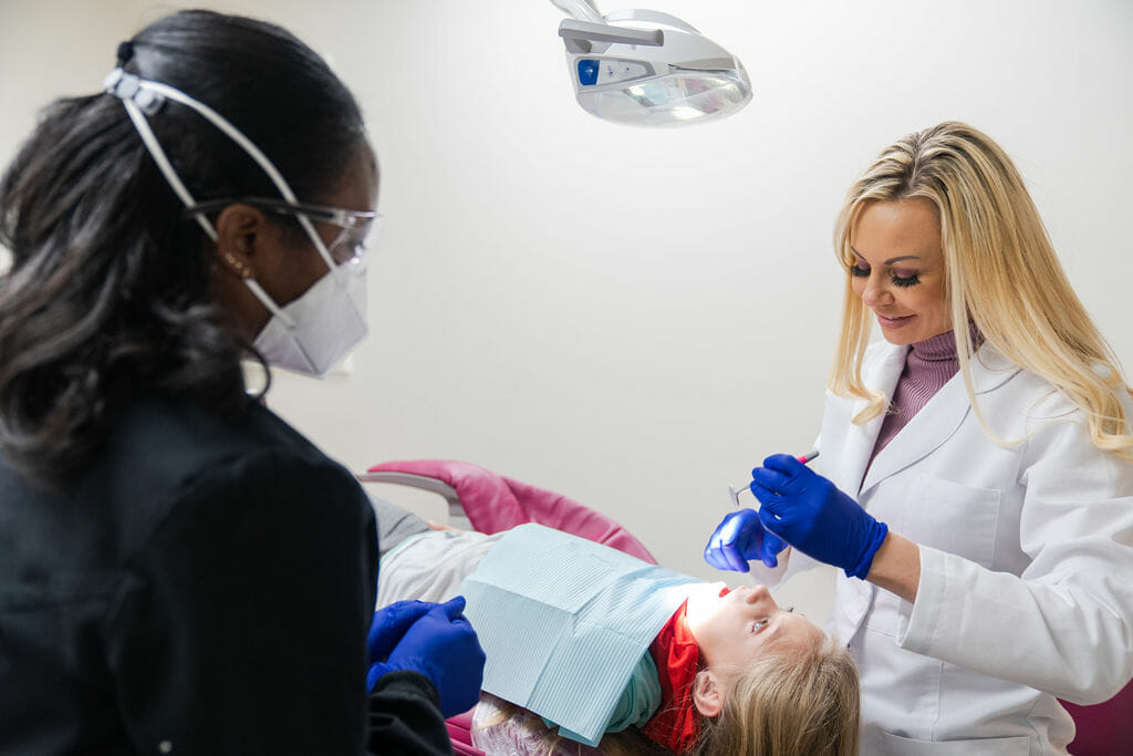 Dr. Wright and dental hygienist working on dental patient in exam room